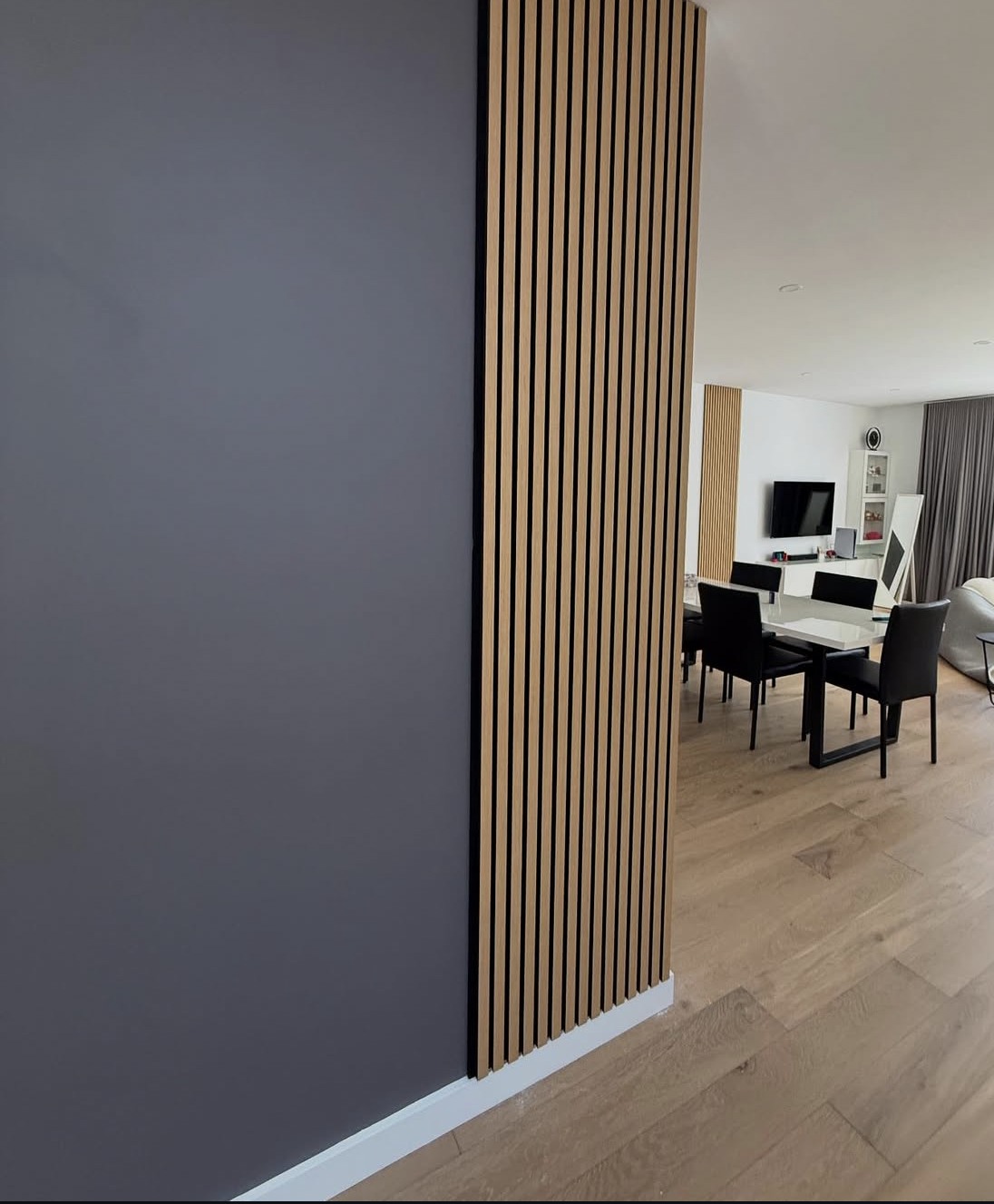 Timber wall panels creating a vertical detail beside a dining area